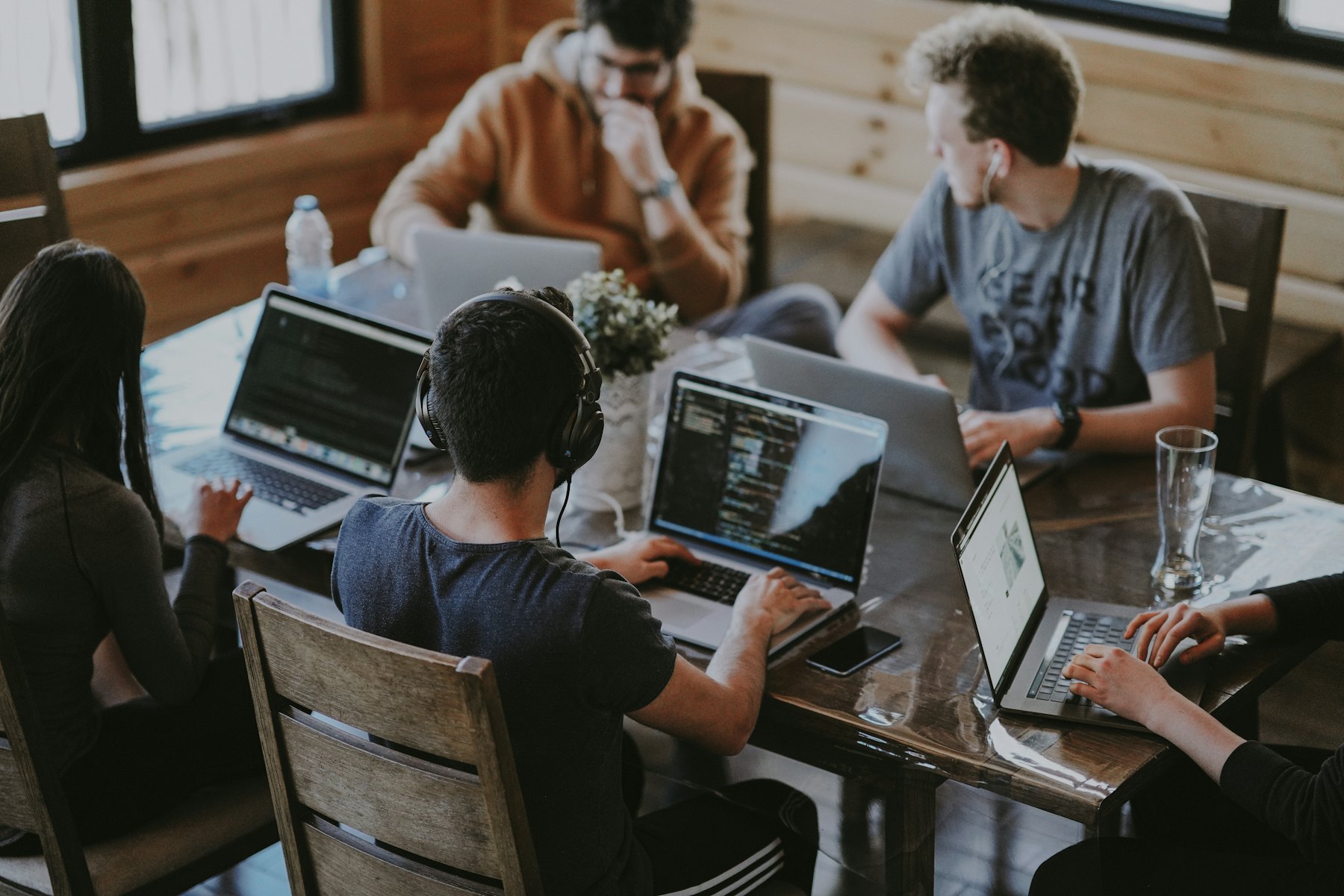 A small team working together around a table with laptops